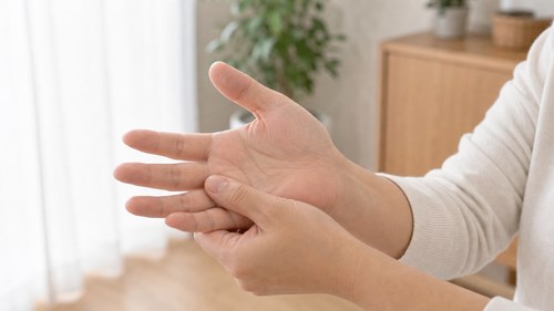 手根管症候群の症状として指先のしびれを確認する様子