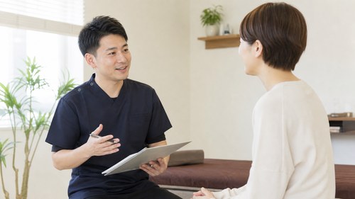 ぎっくり腰の再発予防について整体院で相談する様子