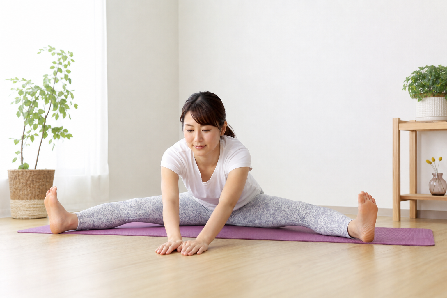 開脚前屈で柔軟性向上のストレッチを行う日本人女性のイメージ