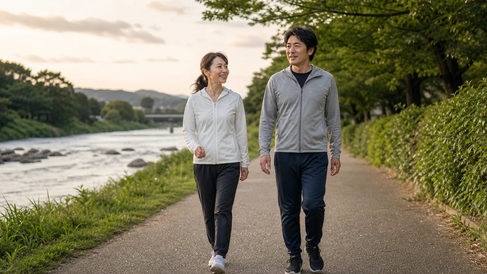 川沿いを一緒に歩く40代の男女