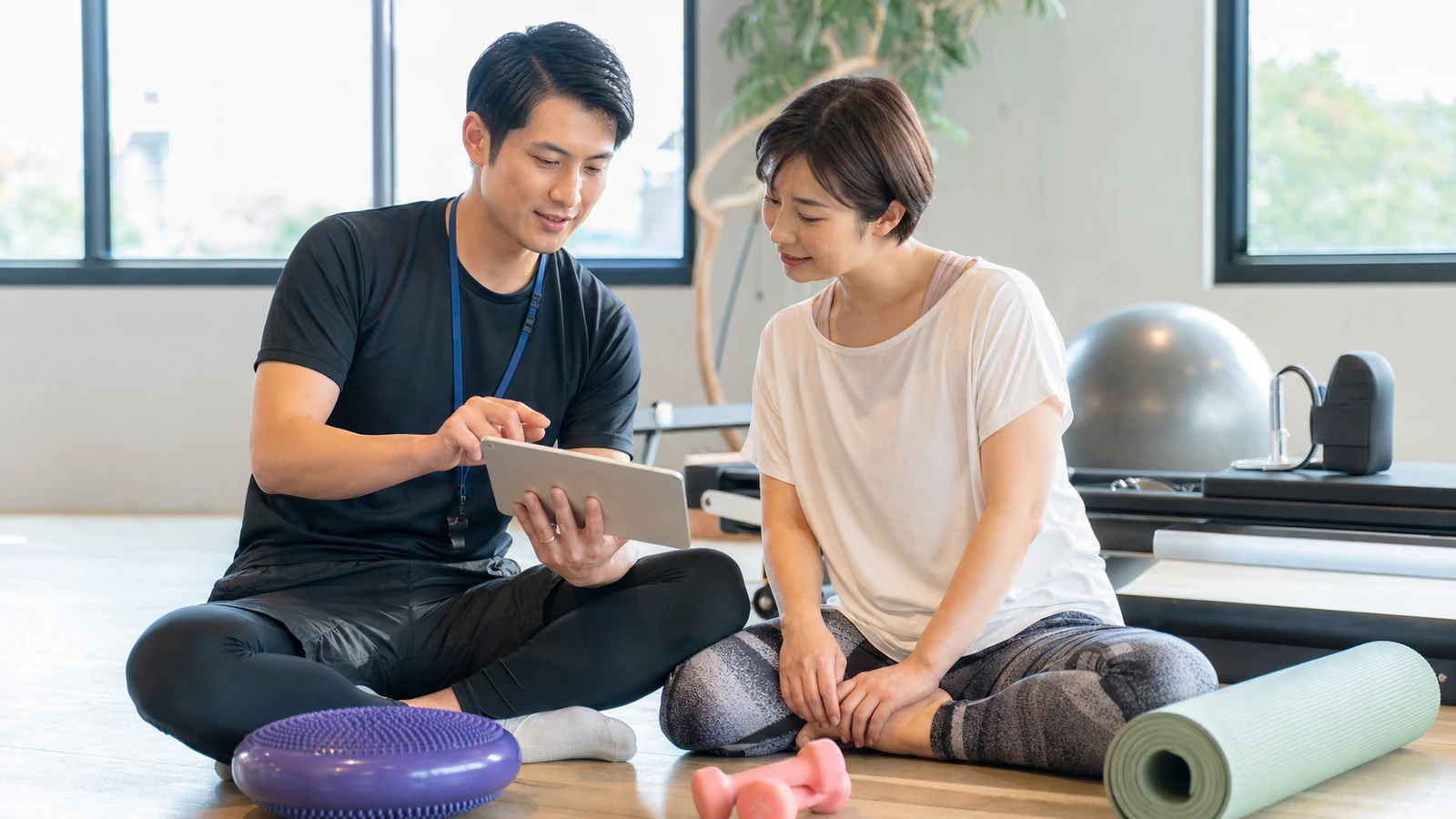 トレーナーと運動計画を相談する女性
