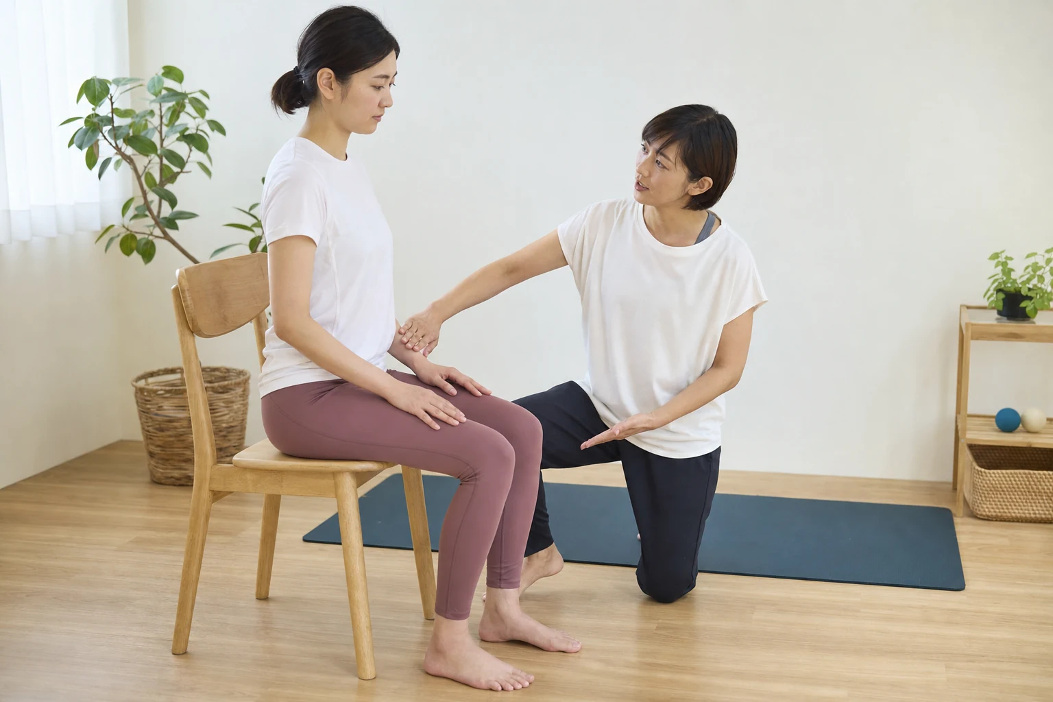 座り姿勢と股関節の位置を確認する女性と専門家