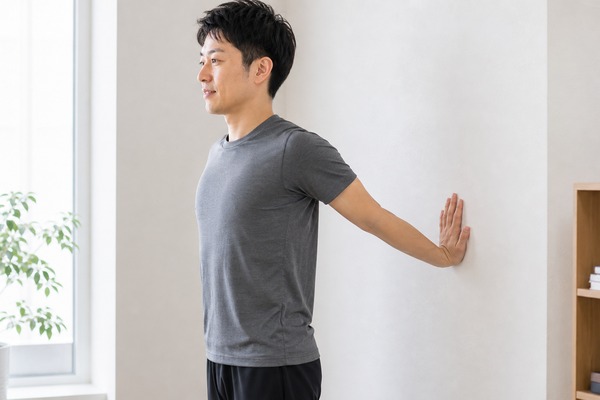 壁を使って上腕二頭筋を伸ばすストレッチ