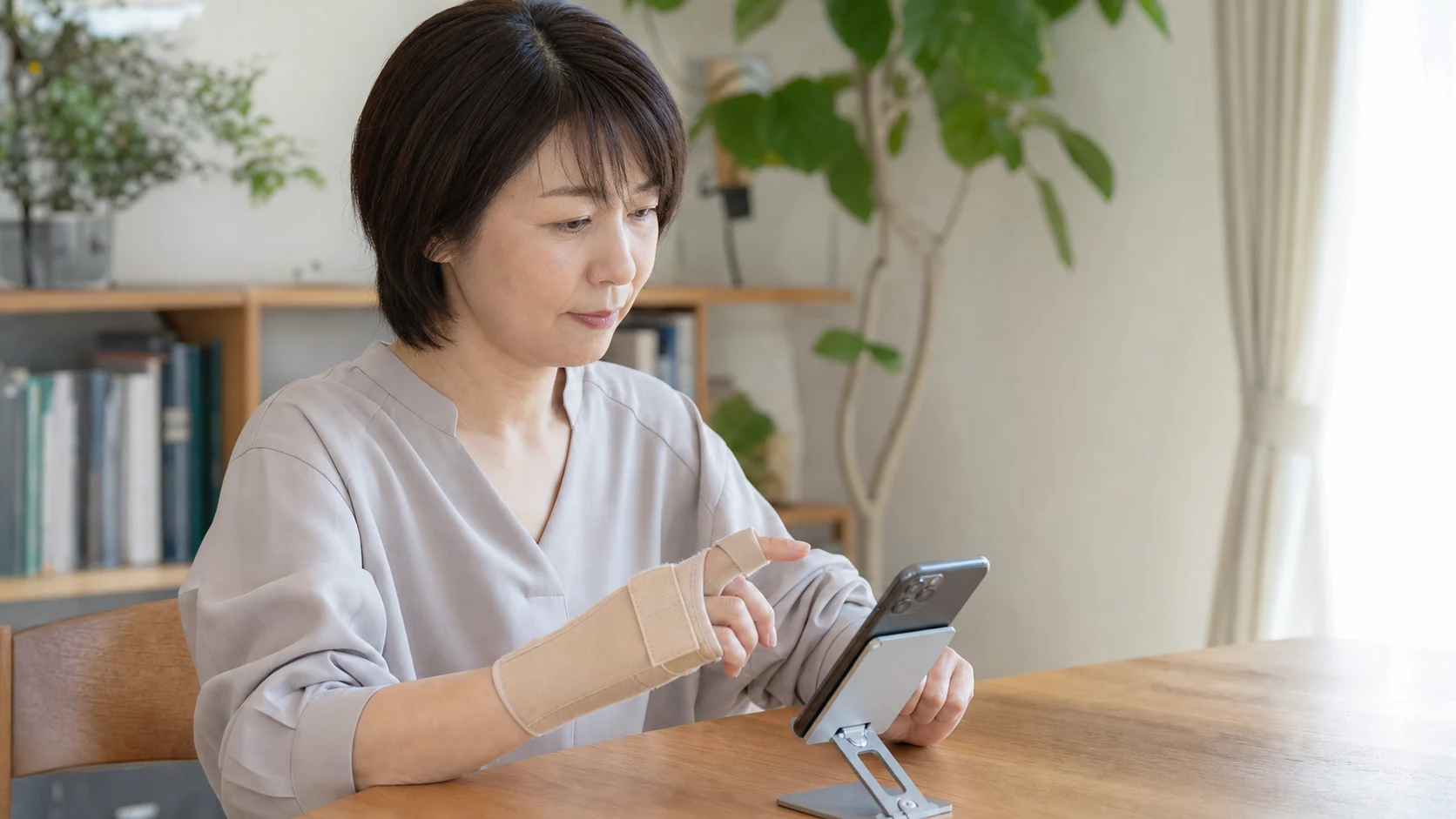 親指用サポーターとスマホスタンドで負担を減らす人