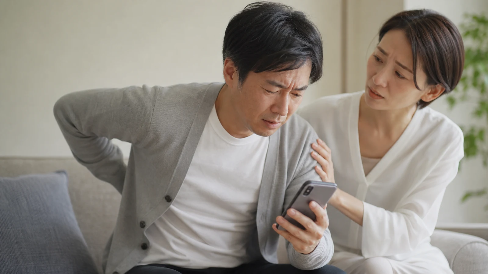 左背中の急な痛みで救急相談をする成人
