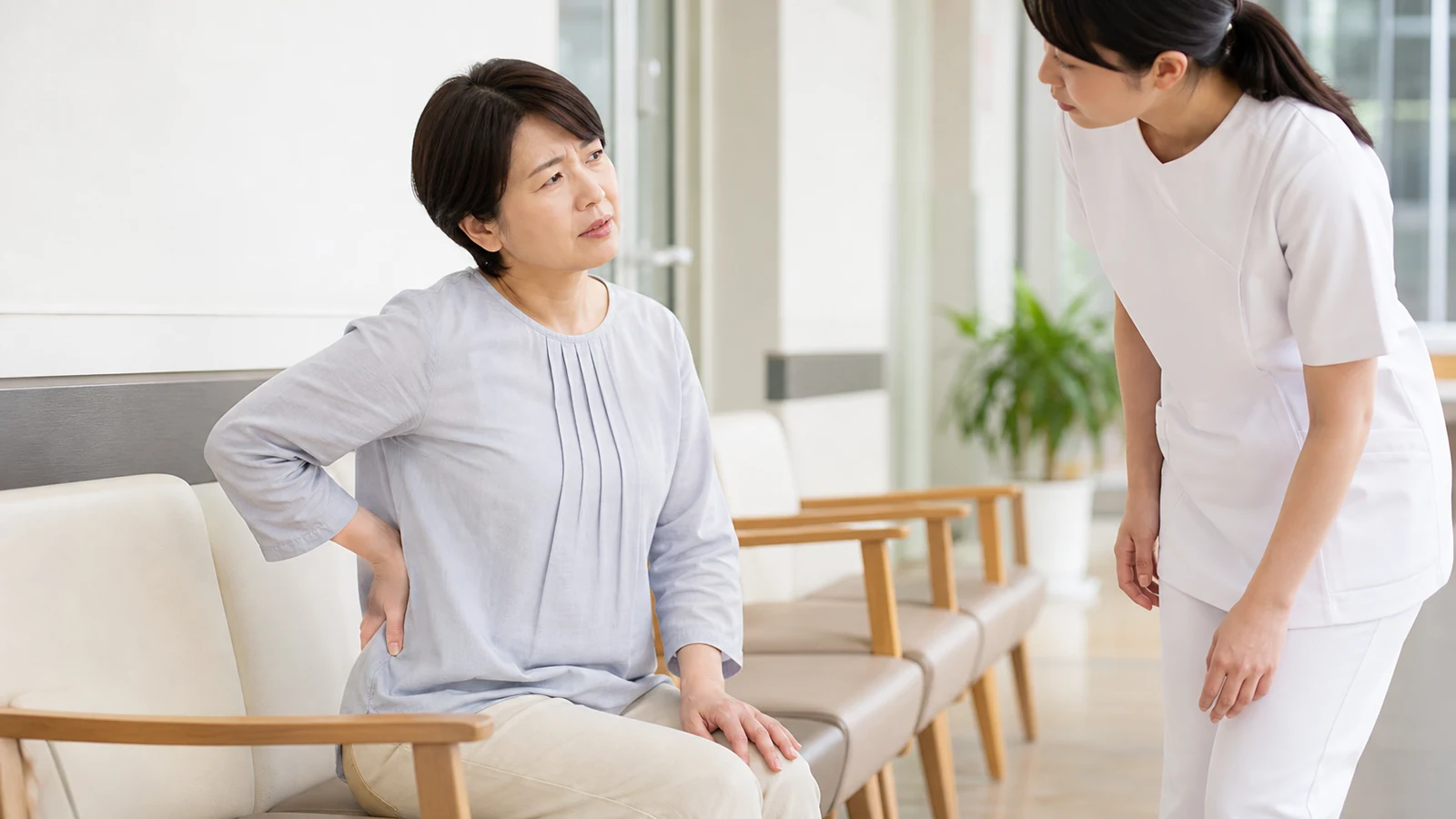 右背中の痛みを看護師へ伝える成人