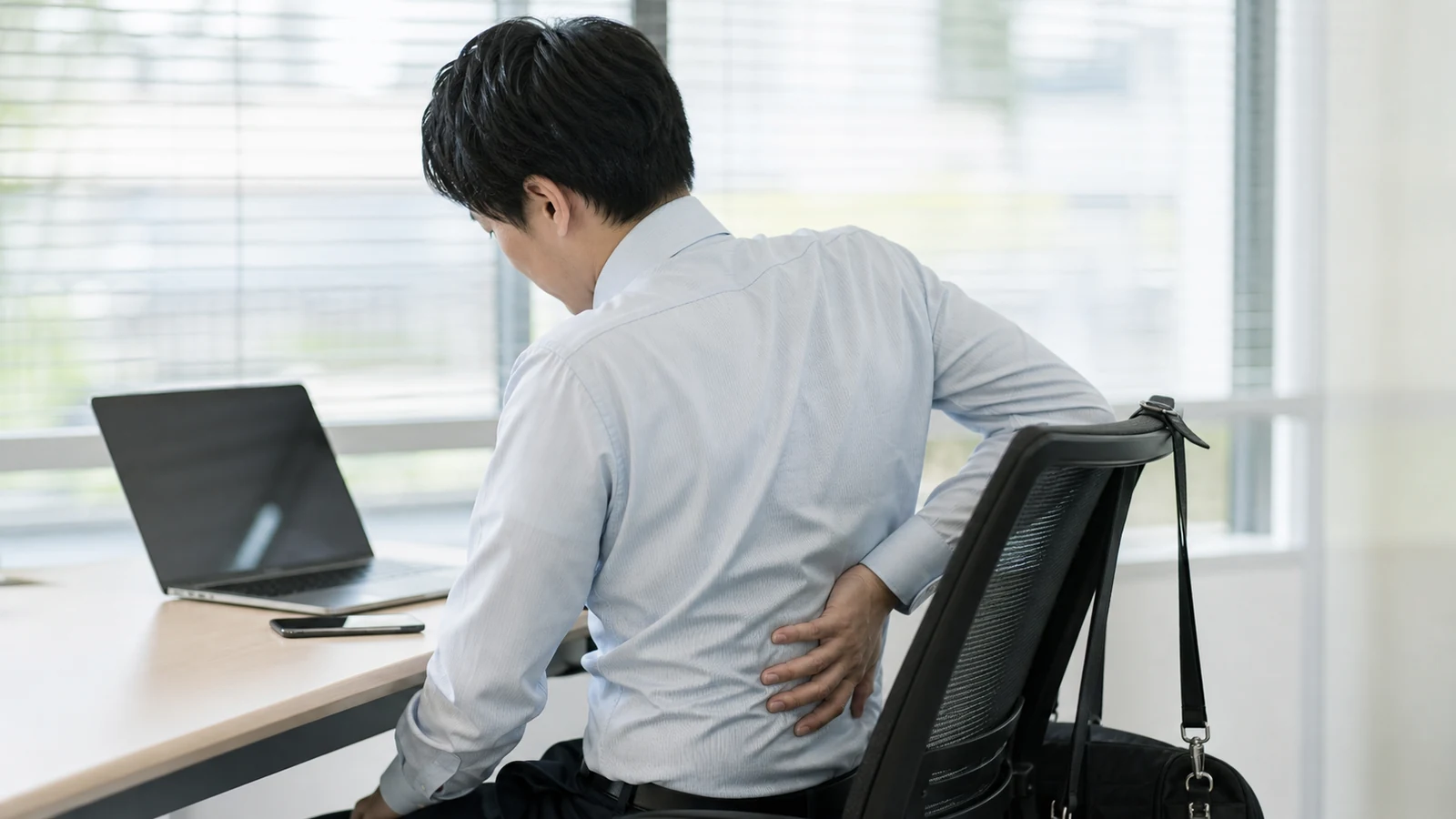 デスクワーク中に背中の右側へ負担を感じる成人