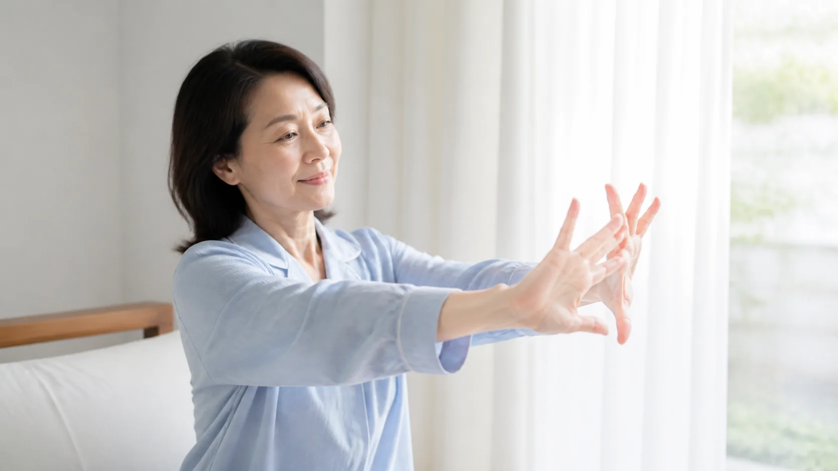 朝起きて指をゆっくり動かす女性