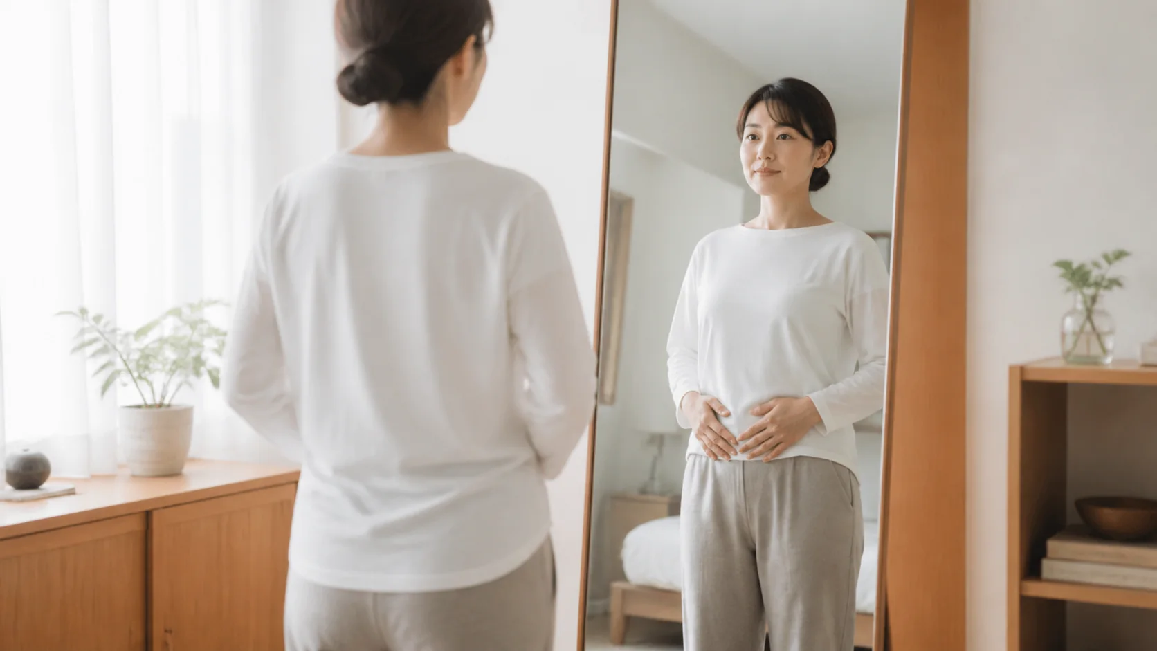 鏡の前で肋骨と姿勢を確認する女性