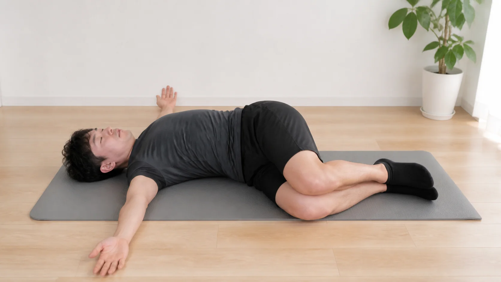 仰向けで胸郭をひらくストレッチを行う男性