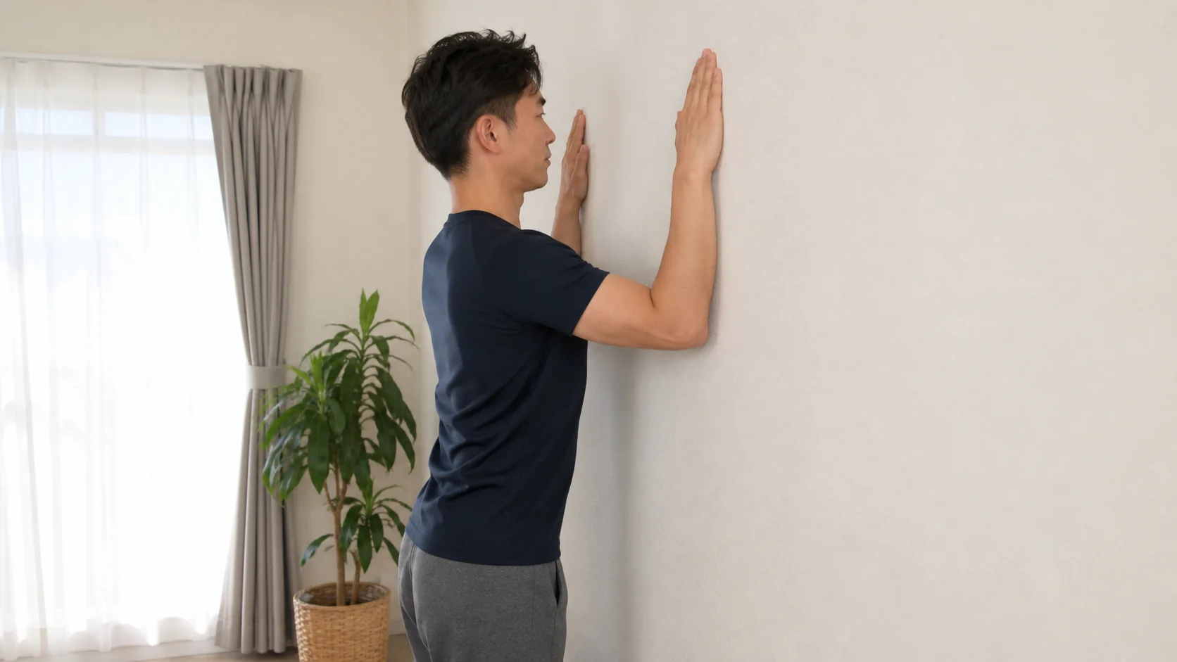 壁を使って肩甲骨を動かす男性