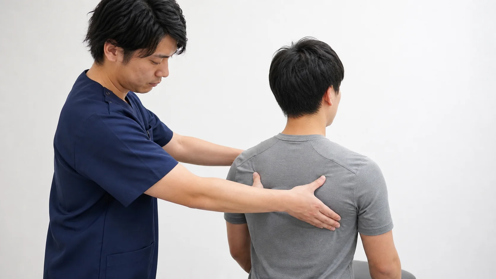 肩甲骨の動きを施術者が確認する男性