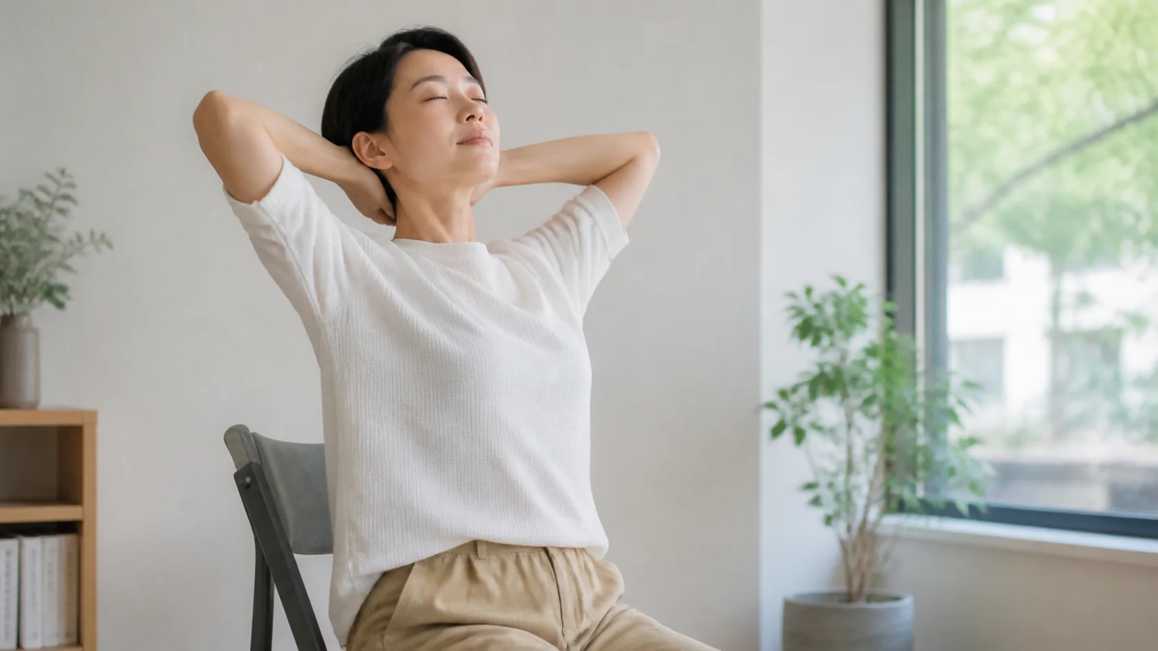 椅子で胸を開いて呼吸する女性