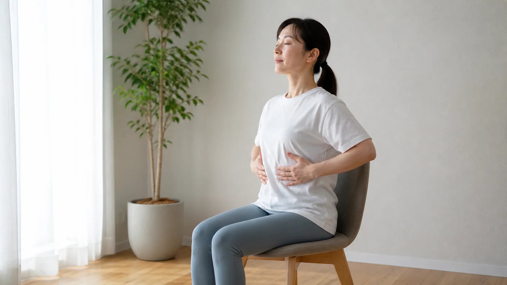 椅子に座って胸郭を広げる呼吸を行う女性
