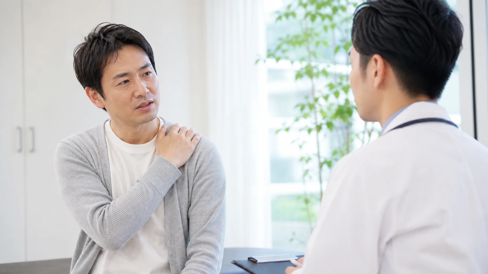 肩の症状について相談する男性