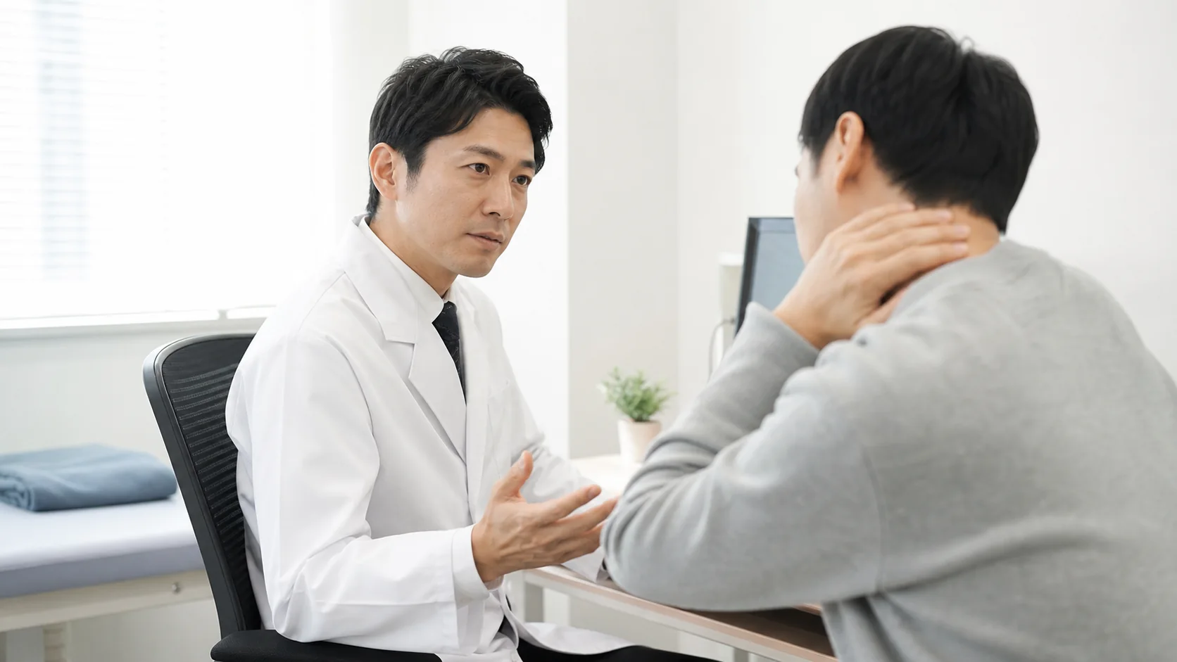 首の痛みについて医師に相談する患者