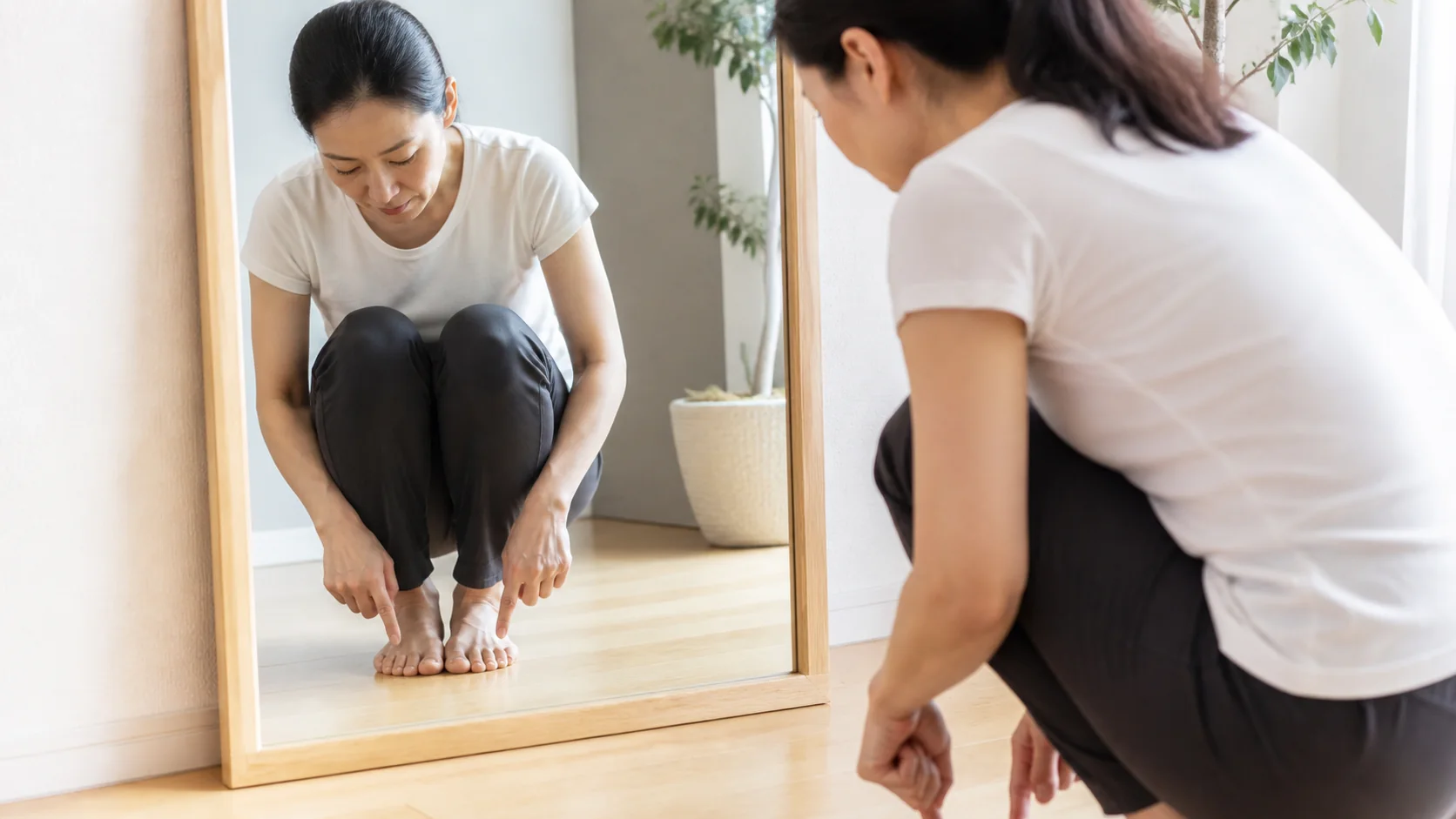 鏡で親指と小指の接地を確認する女性
