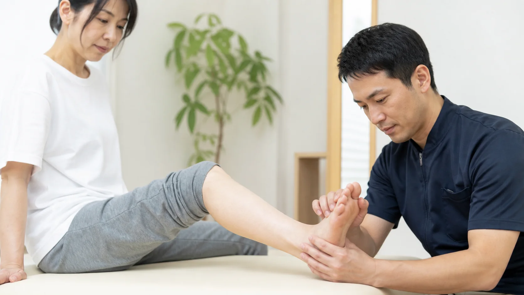 足首と土踏まずを施術者が確認する女性