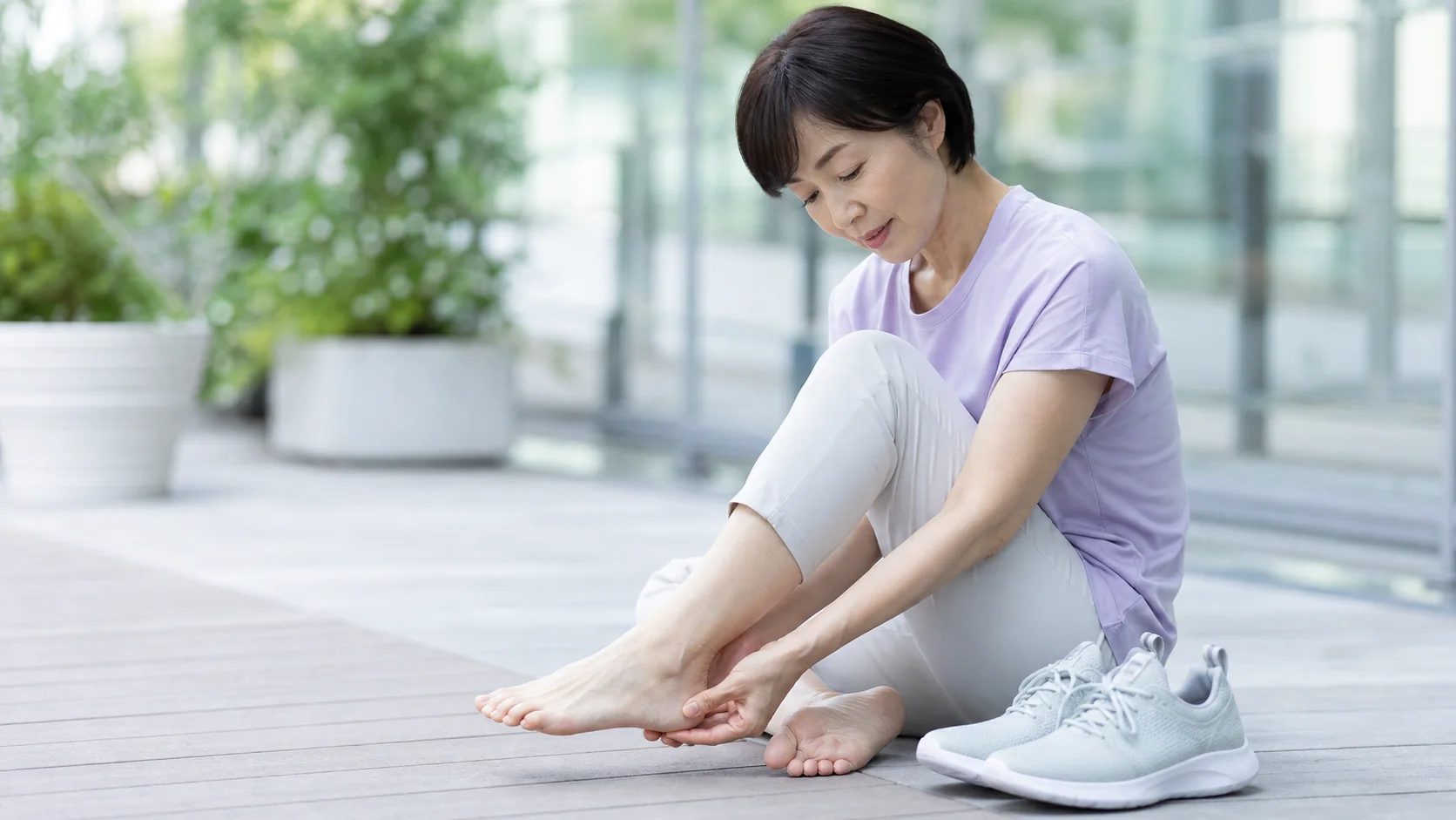 歩いた後に足首の内側を気にする女性