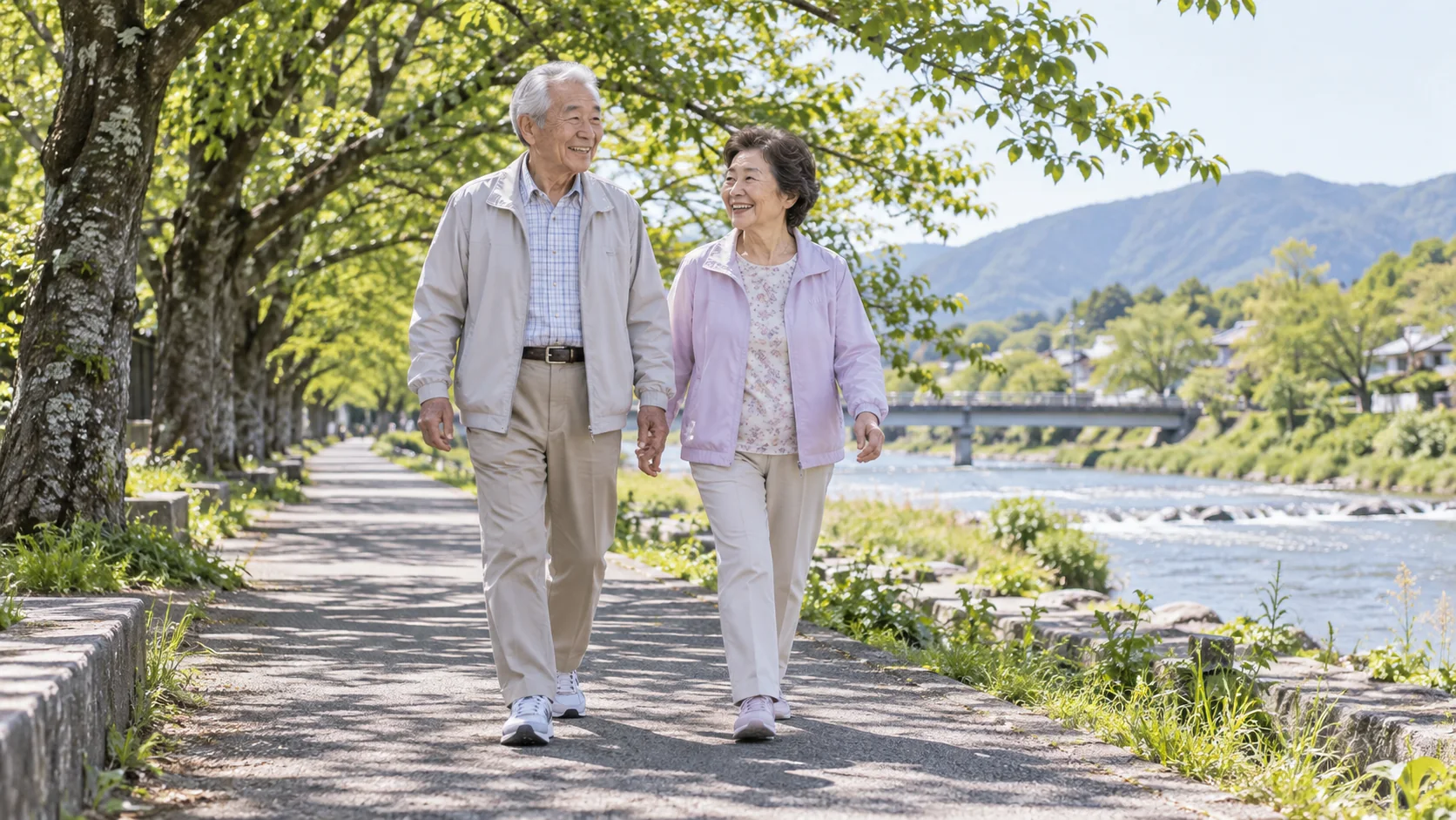 川沿いを並んで歩く高齢の夫婦