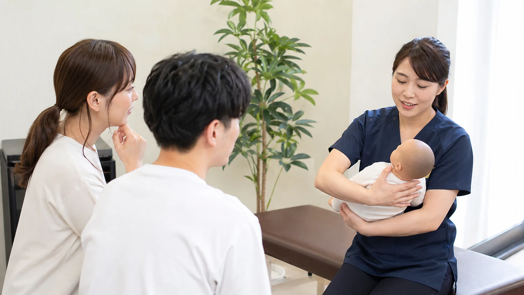 手首に負担の少ない抱き方を専門家へ質問する夫婦