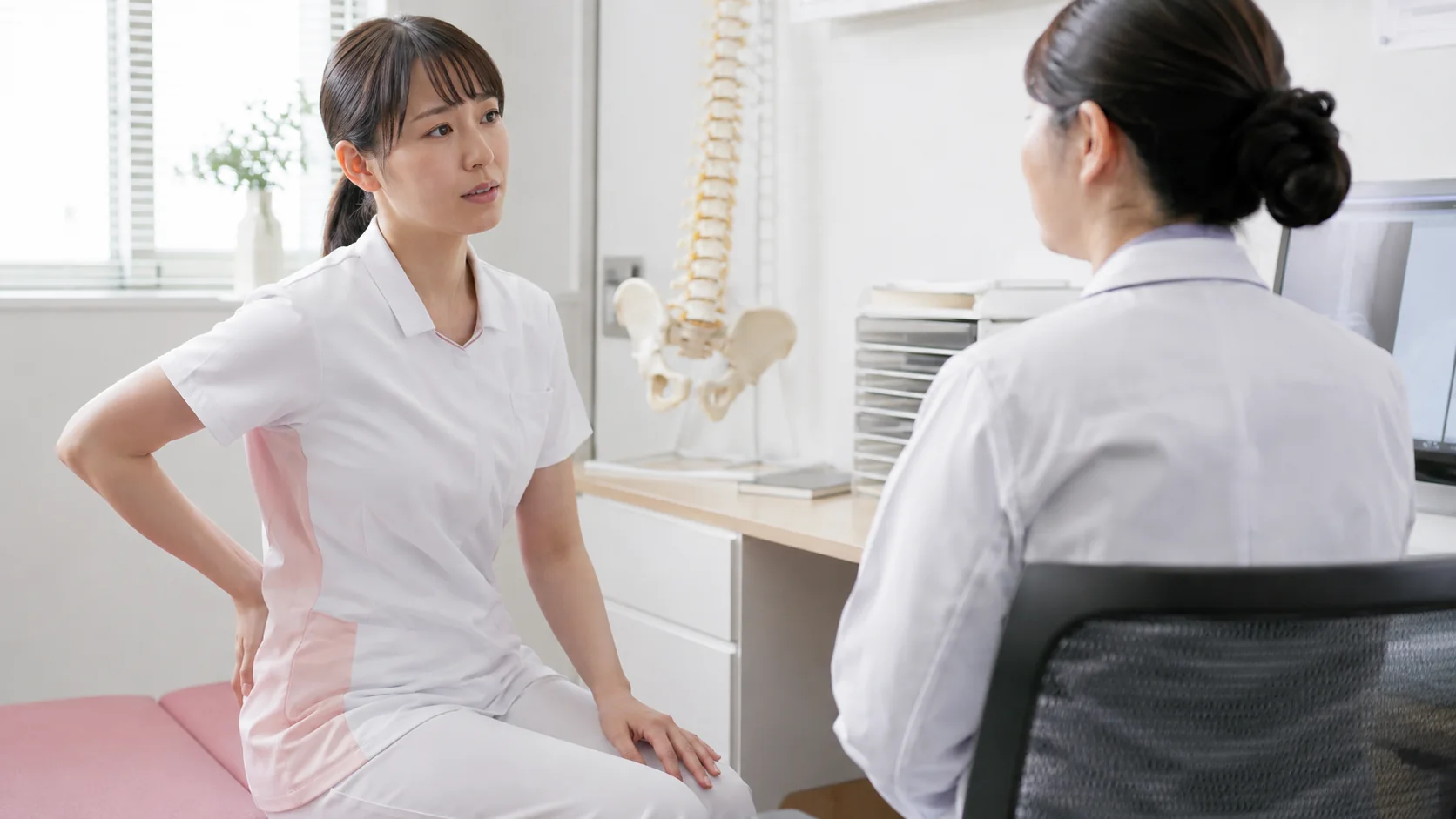 腰痛としびれについて医療機関へ相談する介護士