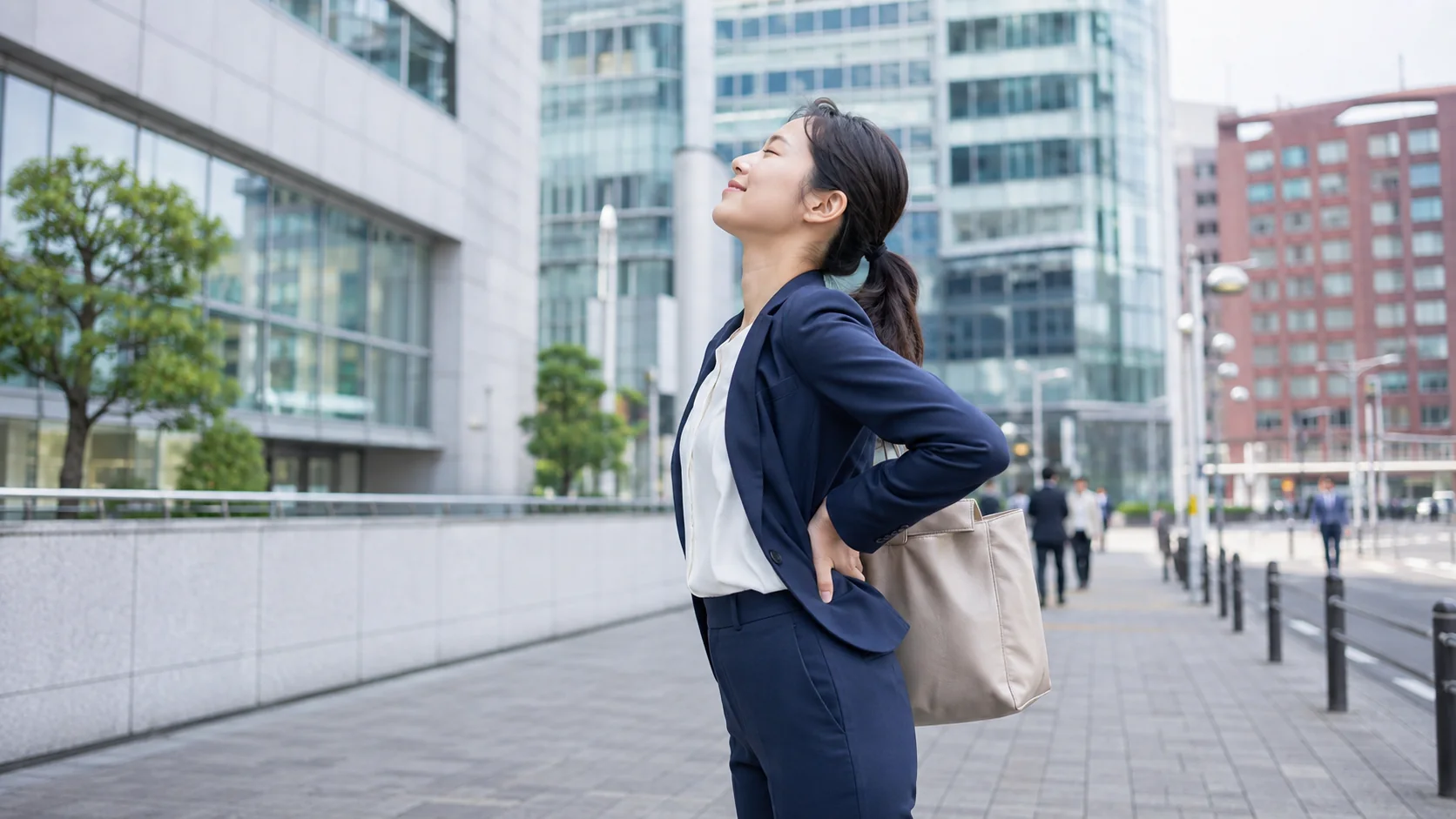 通勤後に歩いて腰を伸ばす女性