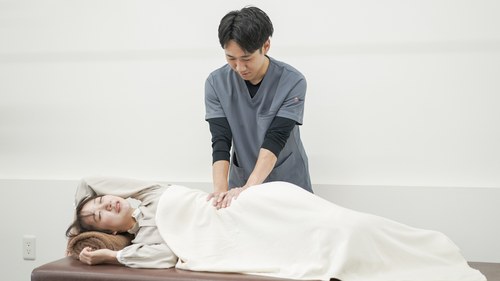整体と手技を組み合わせて腰まわりに施術するイメージ